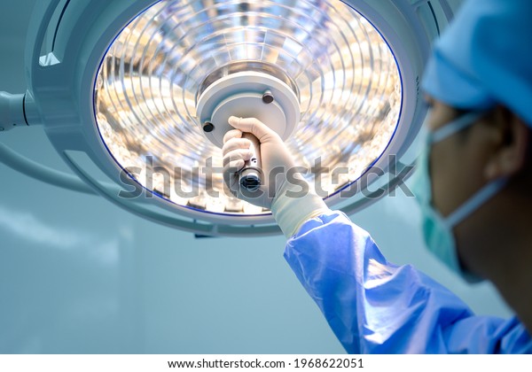 Surgeon or physician\
assistant Surgical lighting is being adjusted to light up when the\
medical team is\
working.