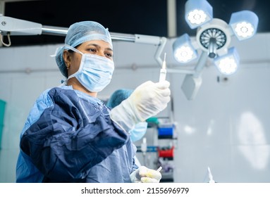 surgeon preparing anaesthesia syringe or injection for surgery at operation theatre - concept of safety, expertise and healthcare specialist