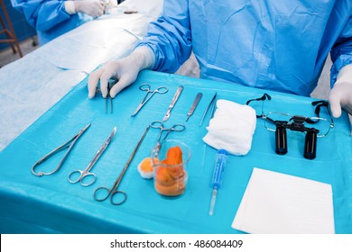 Surgeon With Surgical Tool On Tray In Operation Room At Hospital