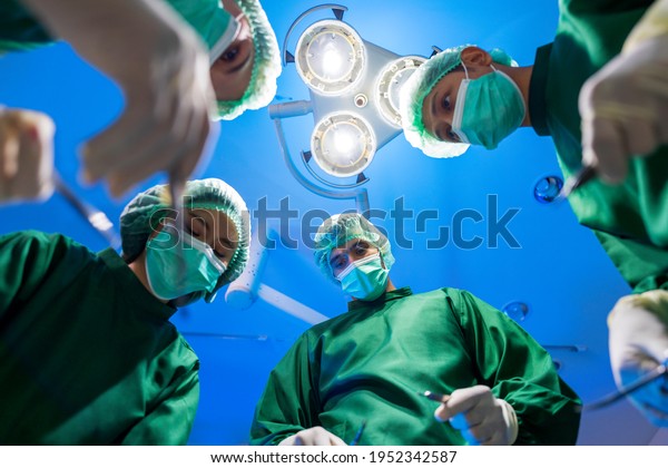 Surgeon team working in operating room.\
Medical team performing\
operation.