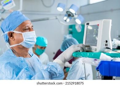 Surgeon In Uniform Using Monitor For Operation To Patient At Operation Theatre - Concept Of Technology, Healthcare And Treatment