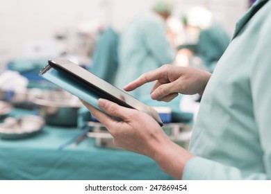 surgeon using digital tablet in operation room
