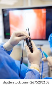 Surgeon using endoscope during procedure. A surgeon skillfully uses an endoscope during a procedure, intently watching the screen for guidance.