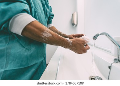 Surgeon washing hands before operating patient in hospital - Medical worker getting ready for fighting against corona virus pandemic - Health care and hygiene concept - Shutterstock ID 1784587109