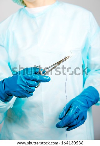 surgeon woman in sterile lab coat and surgical gloves