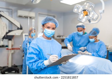 Surgeon writing on clipboard in operation room, anaesthesiologist writing the updates - Powered by Shutterstock