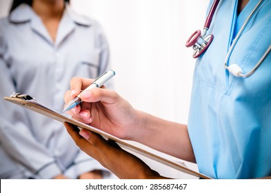 surgeon writing patientâ??s record after examine health