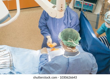 Surgeons or doctor hands with protective glove hold sponge holding a sterilzed gauze with betadine antiseptic liquid for skin to clean or prep wounds and surgical areas in operation room,Health care,