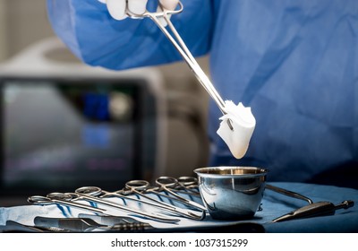 Surgeons Or Doctor Hands With Protective Glove Hold Sponge Holding A Sterilzed Gauze With Betadine Antiseptic Liquid For Skin To Clean Or Prep Wounds And Surgical Areas In Operation Room,Health Care,