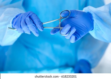 Surgeons hands holding and passing surgical instrument to other doctor while operating patient. Resuscitation medicine team holding steel medical tools saving patient. Surgery and emergency concept