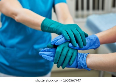 surgeons joining hands together after work for rescue patient in operation room at hospital, emergency case, surgery, medical technology, disease treatment concept - Powered by Shutterstock