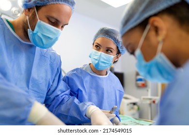 Surgeons In A Light Operating Room Perform Plastic Surgery, A Team Of Male And Female Doctors Perform Reconstructive Surgery.