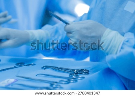 Surgeons in operating room performing procedure with surgical instruments.