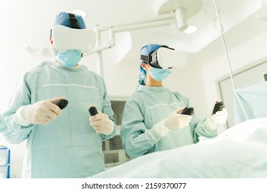 Surgeons at the operating room using controllers and virtual reality glasses while performing surgery remotely - Powered by Shutterstock