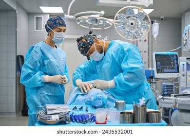 Surgeons perform complex surgery in the operating room - Powered by Shutterstock