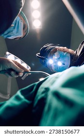 Surgeons Performing Complex Surgery Under Bright Operating Room Lights With Loupes and Masks