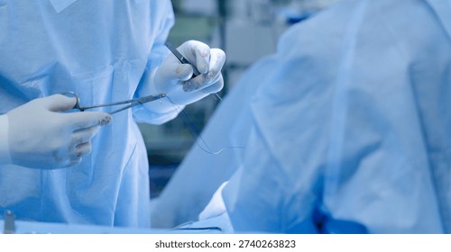 Surgeons performing delicate procedure in operating room.
