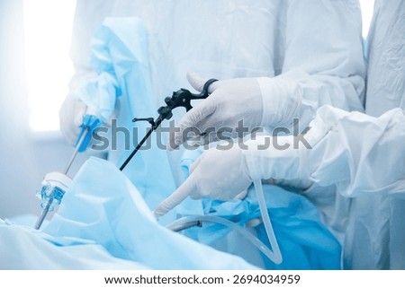 Surgeons performing laparoscopic surgery in operating room with precision.