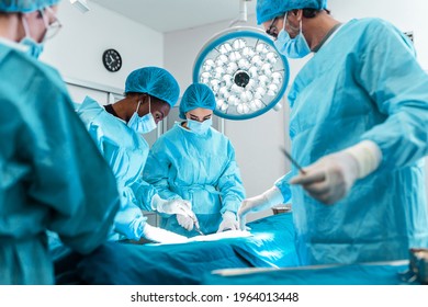 Surgeons performing operation in operation theater. breast augmentation surgery in the operating room surgeon tools implant. Medical care concept.