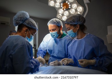 Surgeons performing operation in operation theater. breast augmentation surgery in the operating room surgeon tools implant. Medical care concept. - Powered by Shutterstock