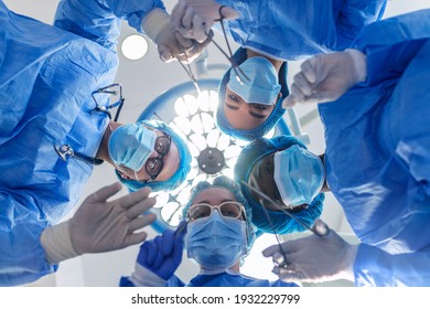 Surgeons standing above of the patient before surgery. Multi-ethnic healthcare workers performing surgery on patient at operation theater. - Powered by Shutterstock