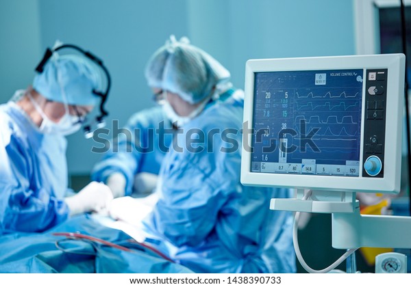 A surgeon\'s team in uniform performs an\
operation on a patient at a cardiac surgery clinic. Modern\
medicine, a professional team of surgeons,\
health.