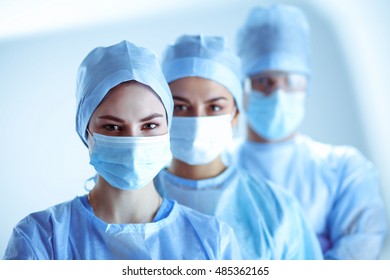 Surgeons Team, Wearing Protective Uniforms,caps And Masks 