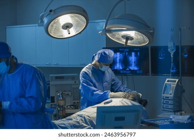 Surgeons team working with Monitoring of patient in surgical operating room. The doctors and nurses brainstorm power assisted surgery. A team of professional doctors perform surgery in a hospital - Powered by Shutterstock