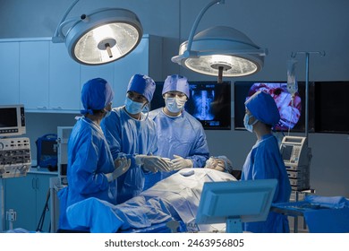 Surgeons team working with Monitoring of patient in surgical operating room. The doctors and nurses brainstorm power assisted surgery. A team of professional doctors perform surgery in a hospital - Powered by Shutterstock