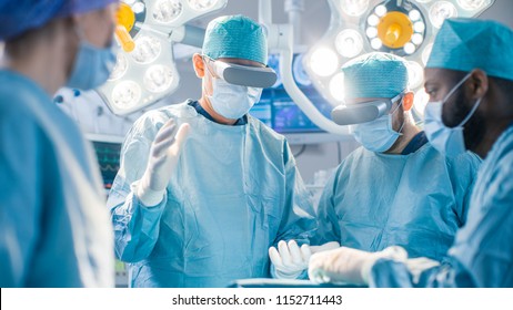 Surgeons Wearing Augmented Reality Glasses Perform State Of The Art Augmented Reality Surgery In High Tech Hospital. Doctors And Assistants Working In Operating Room.