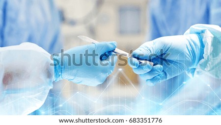 surgery, medicine and people concept - close up of surgeons hands with scalpel at operation in operating room at hospital