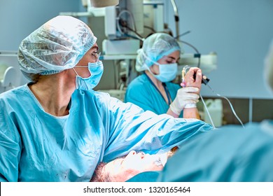 surgery, medicine and people concept - group of surgeons at operation in operating room at hospital