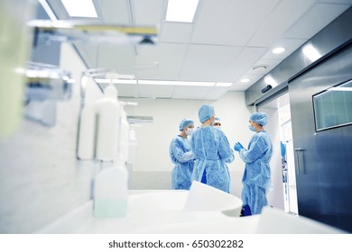 surgery, medicine and people concept - group of surgeons in operating room at hospital talking and preparing to operation - Powered by Shutterstock