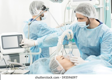 Surgery Preparations. Surgical Team Preparing Their Patient For Surgery Adjusting Oxygen Mask Checking Monitors At The Operating Room Healthcare Medicine Professionalism Teamwork Doctors Copyspace 