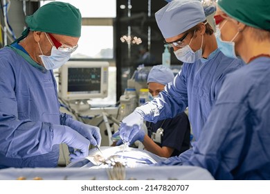 Surgery team working together in a surgical room on patient. Medical team of professional surgeons performing surgery in the hospital operation theater. Heart rate monitor during operation. - Shutterstock ID 2147820707