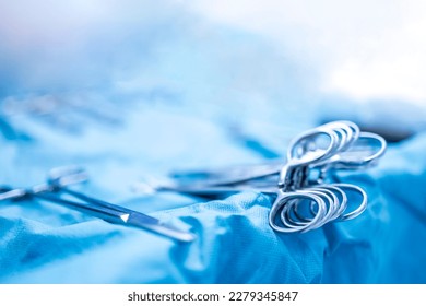 Surgical clamps and medical equipment on surgical tray.Surgical scissors on medical table intend to blur background inside operating room.Medical tools inside operating theater when surgery was done.