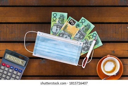 Surgical Face Mask and Australian dollars on wooden table. Coronavirus and finance concept