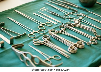 surgical instruments and tools including scalpels, forceps and tweezers arranged on a table for a surgery
