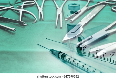 Surgical instruments with vial of drug and syringe on green background