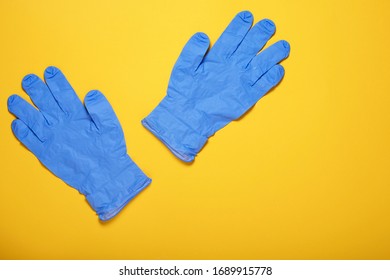 Surgical Latex Gloves On Yellow Background, Flat Lay. Coronavirus Prevention, Medical Supplies Shortage