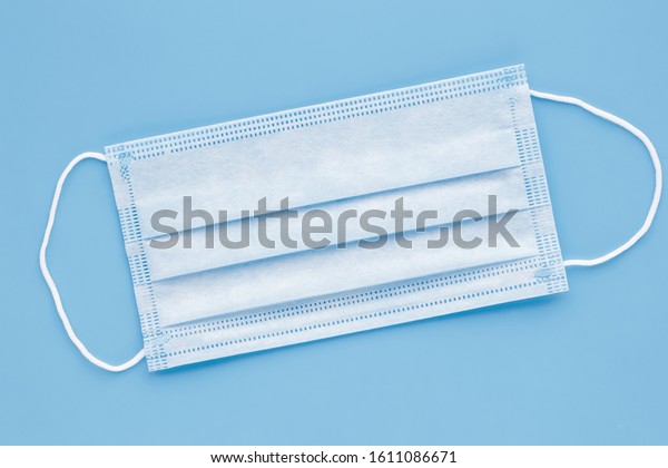 Surgical mask with rubber ear straps. Typical\
3-ply surgical mask to cover the mouth and nose. Procedure mask\
from bacteria. Protection\
concept.