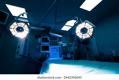 Surgical operating. Wide angle photo with the bright lights and operation table in moody dark light. Hospital image. - Powered by Shutterstock