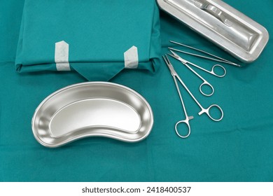 Surgical set and medical equipment on green surgical tray inside operating room.Sterile surgical instrument tool equipment for surgery.Infection control - Powered by Shutterstock