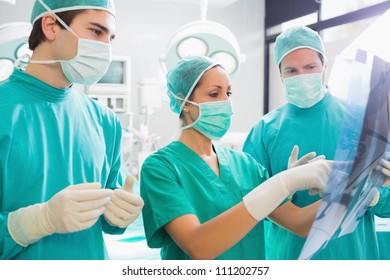 Surgical team analyzing a X-ray in an operating theater, Healthcare workers in the Coronavirus Covid19 pandemic