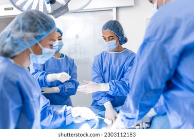 Surgical team performing surgery in modern operation theater,Team of doctors concentrating on a patient during a surgery,Team of doctors working together during a surgery in operating room, - Powered by Shutterstock