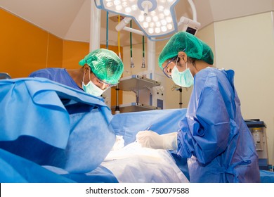 The surgical team is performing surgery for the patient in the operating room.