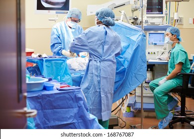 Surgical Team Working In Operating Theatre