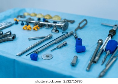 Surgical tools on a blue drape. A variety of surgical instruments are carefully laid out on a blue table cover, ready for use in a medical procedure. - Powered by Shutterstock