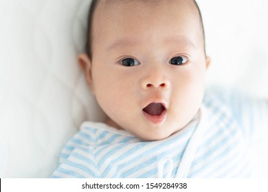 Surpried baby lying on bed