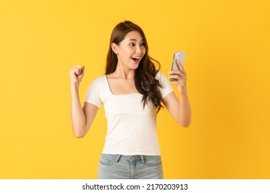 Surprise Asian Beautiful Woman Isolate On Yellow Background Using Smartphone